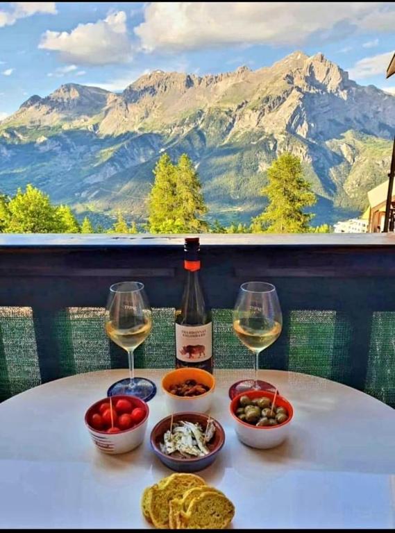 a table with a bottle of wine and two glasses at STUDIO 4 personnes in Les Prés