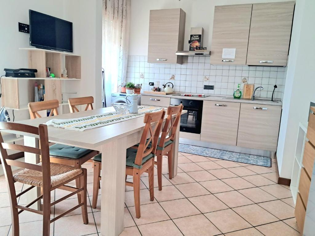 a kitchen with a table and chairs and a kitchen with white cabinets at Tolle Economy Stay in Padova