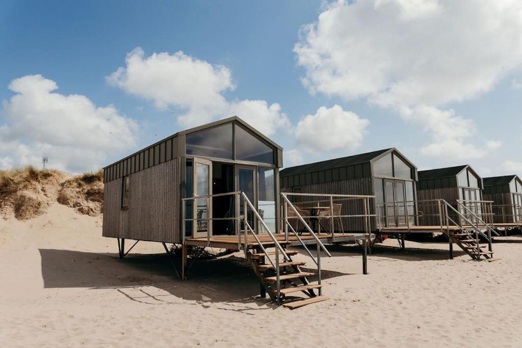 a row of tiny houses sitting on the beach at Puur Petten in Petten