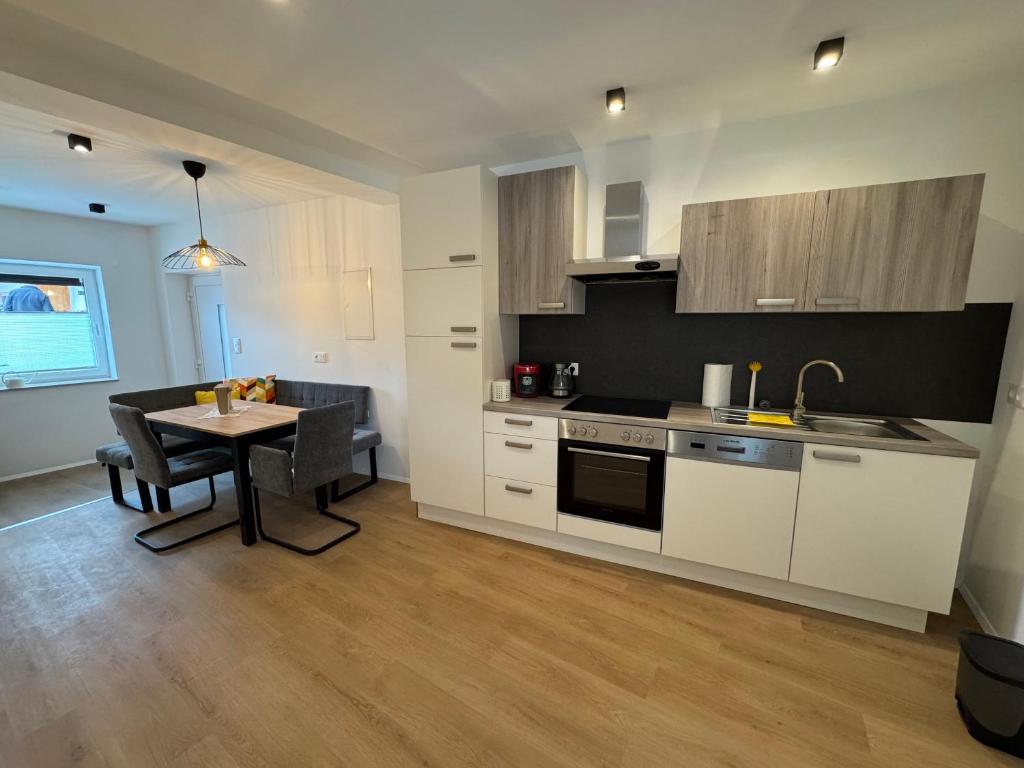 a kitchen and dining room with a table and a kitchen and a dining room at Ferienwohnung Hofblick in Krustetten
