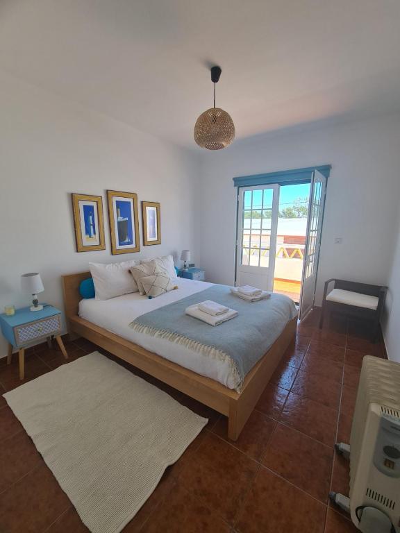 a bedroom with a large bed and a window at Dunas Rest in Odemira