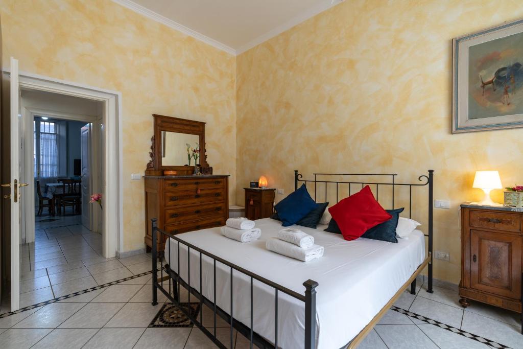 a bedroom with a bed with red and blue pillows at Green Square Apartment 14 Min from Santa Croce with Hydromassage Tub in Florence
