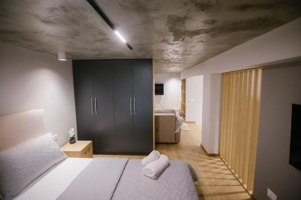 a bedroom with a bed and a room with a tv at Triple Nest Korce in Korçë