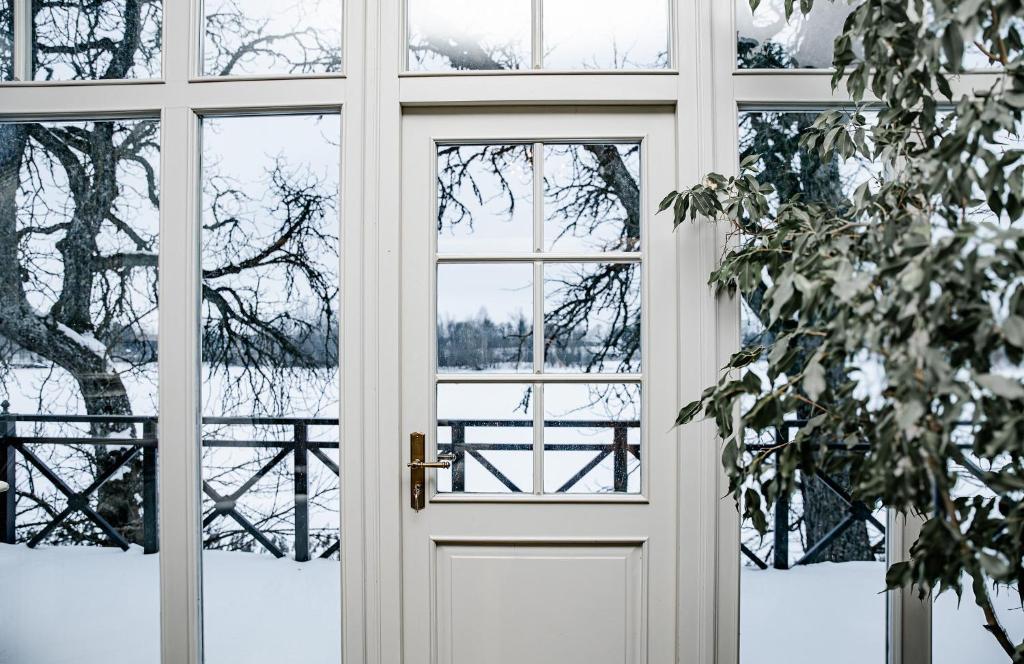 a door with a view of a snowy yard at Piena māja in Kukšas