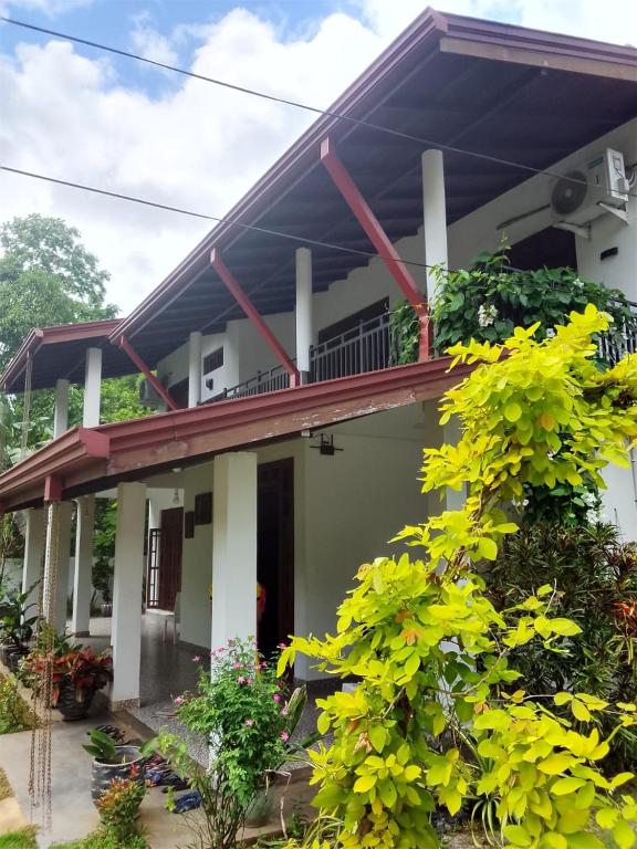 a house with a balcony and some plants at Amantha Holiday Resort in Anuradhapura