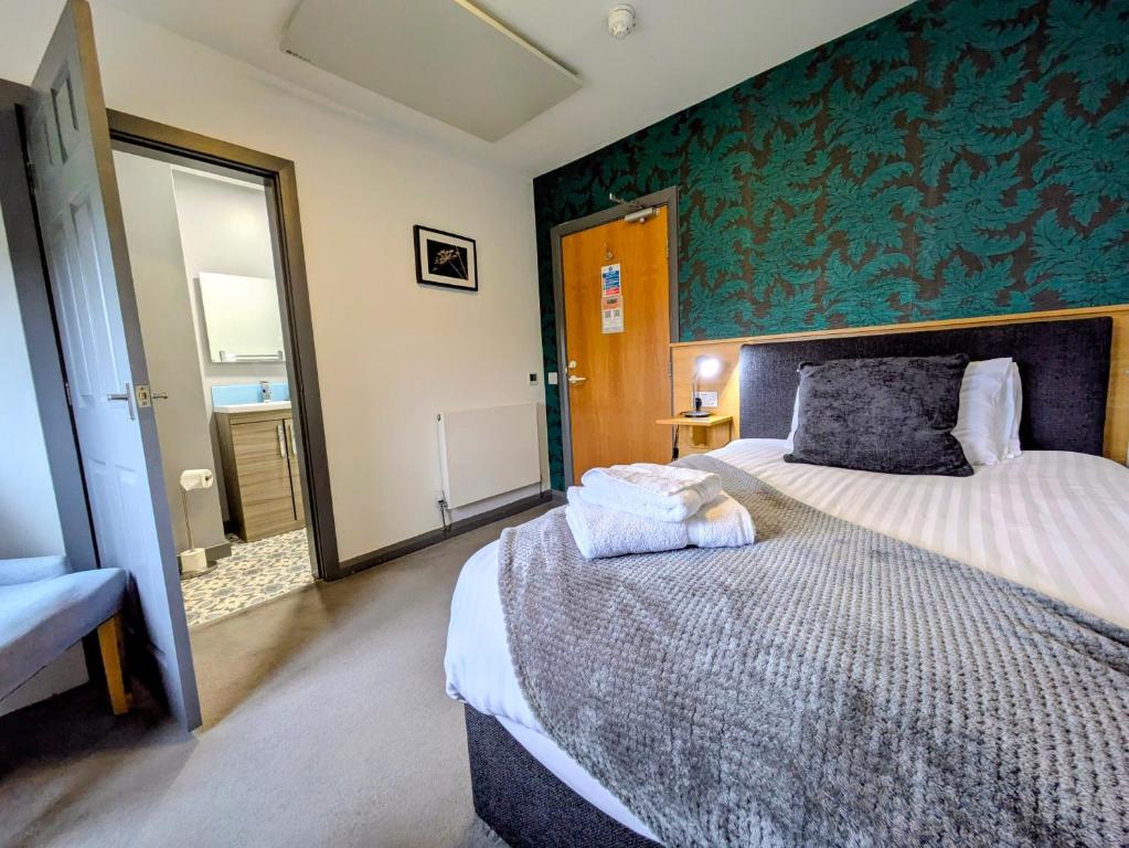 a bedroom with a bed and a green wall at West Point House in Barrow in Furness