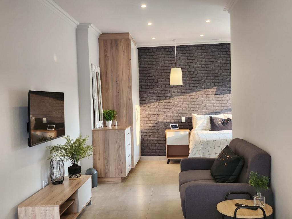 a living room with a couch and a bedroom at Executive Suites Brackenhurst in Alberton