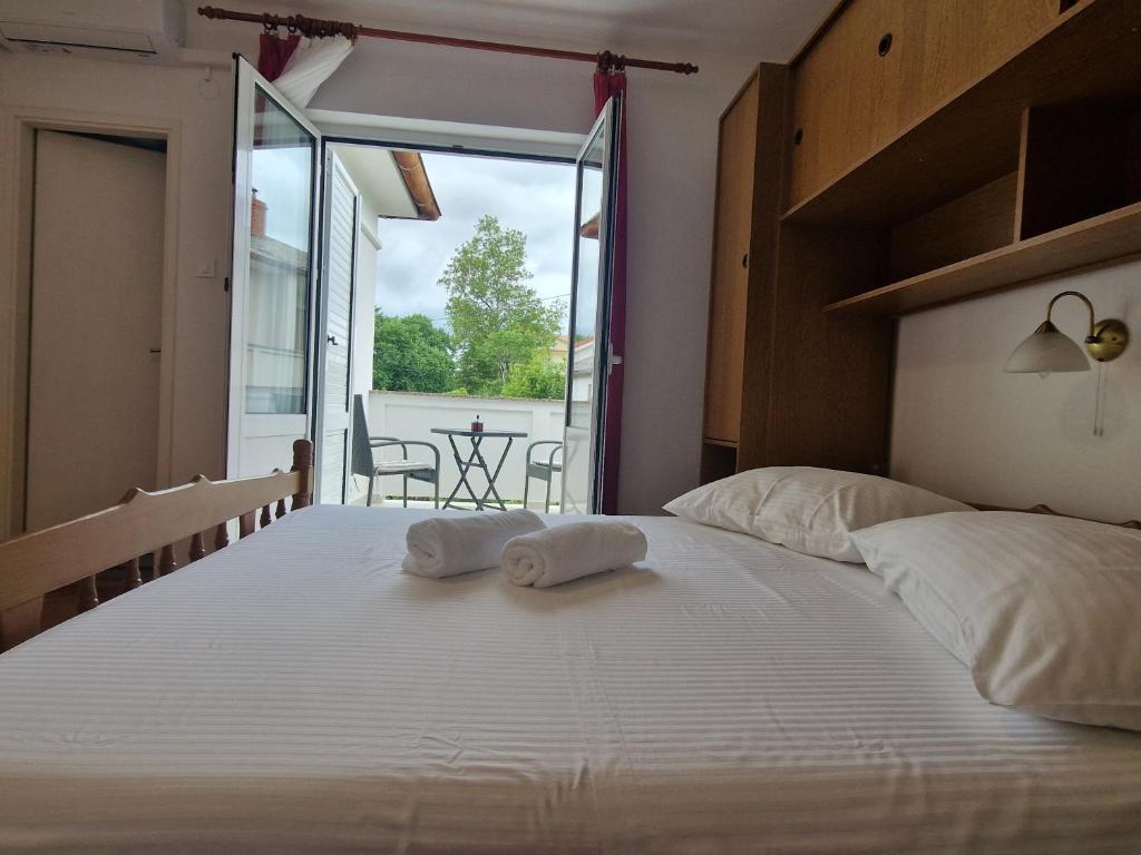 a bedroom with a large bed with two towels on it at Rooms Čapo Rab in Palit