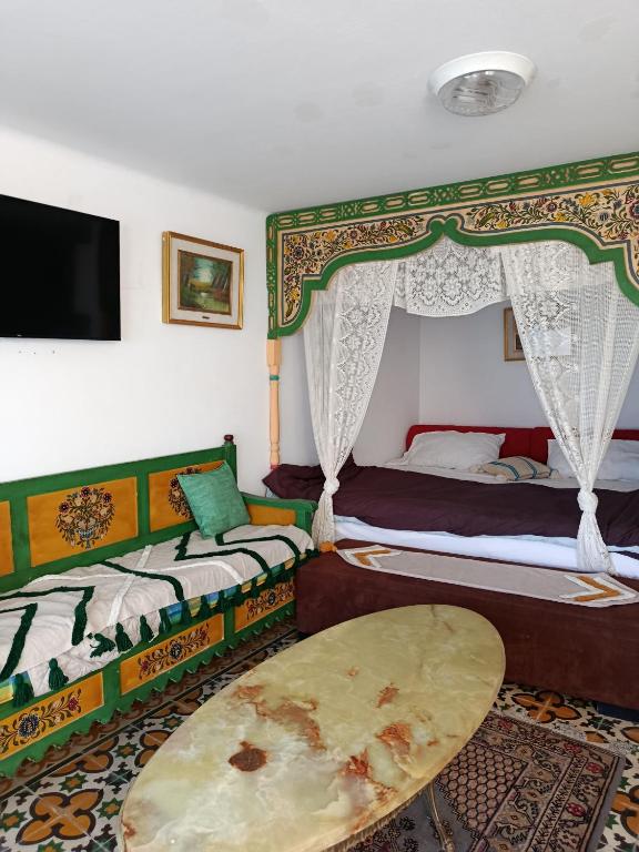 a bedroom with two beds and a flat screen tv at Studio Traditionnel a louer-Mahdia in Mahdia