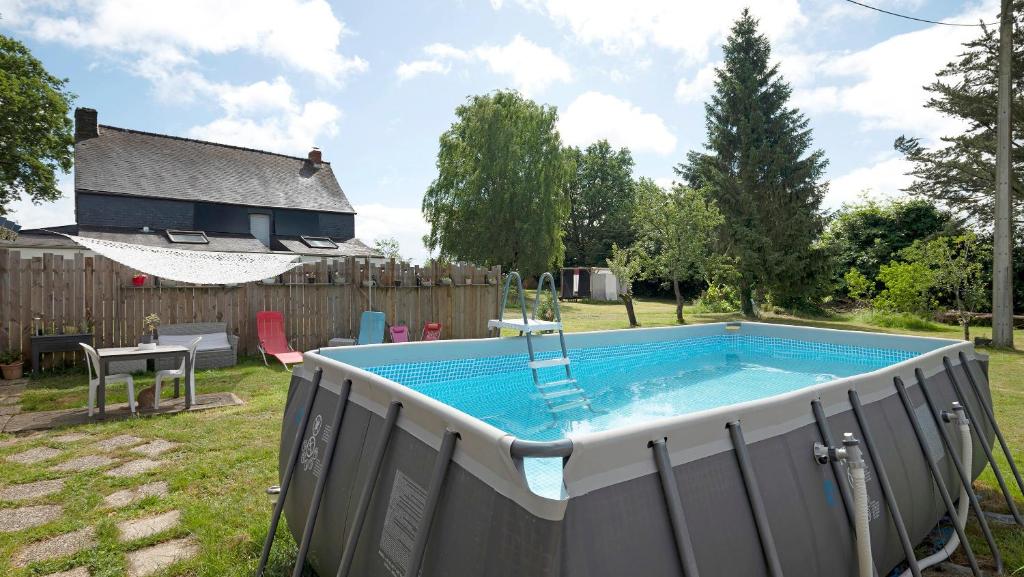 a swimming pool in the backyard of a house at Gîte Le Relais De Jehan in Saint-Malo des 3 Fontaines