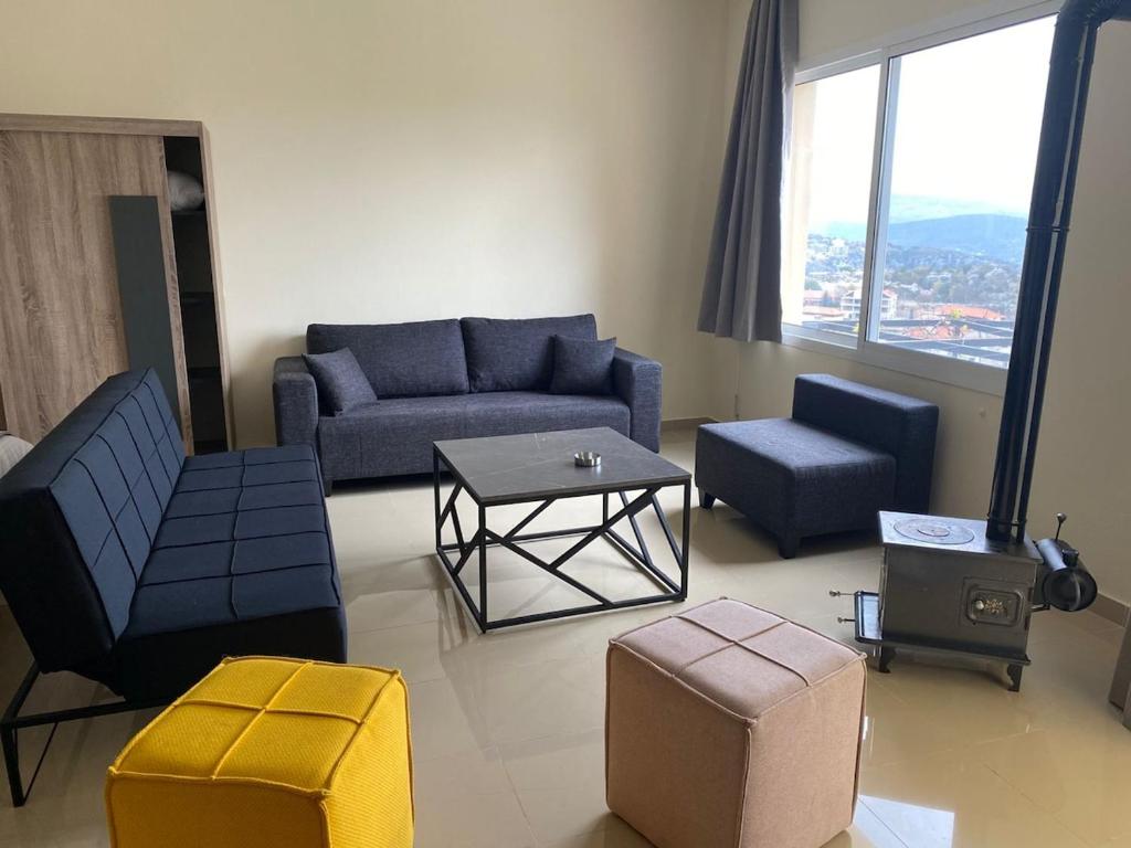 a living room with a blue couch and a table at Chalet 103 - Zresidence - Faitroun in Al ‘Aqabah