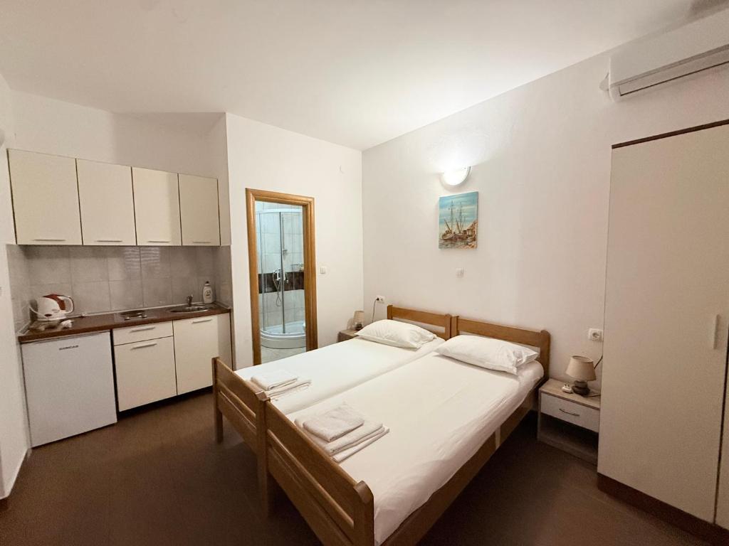 a bedroom with a large bed and a kitchen at Apartments Tomislav in Vodice