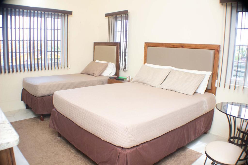 a bedroom with two beds and a table and windows at The Vista Inn Studio #2 in Falmouth