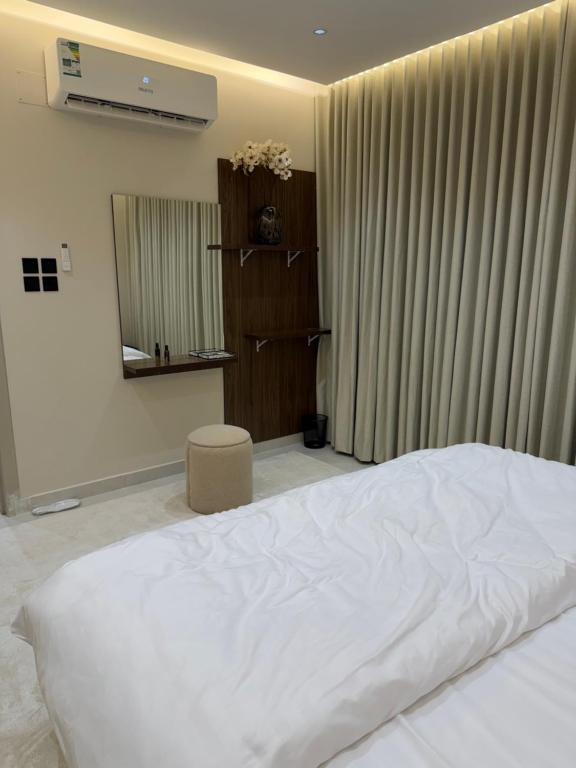 a bedroom with a white bed and a window at شقة مودرن غرفة وصالة in Buraydah
