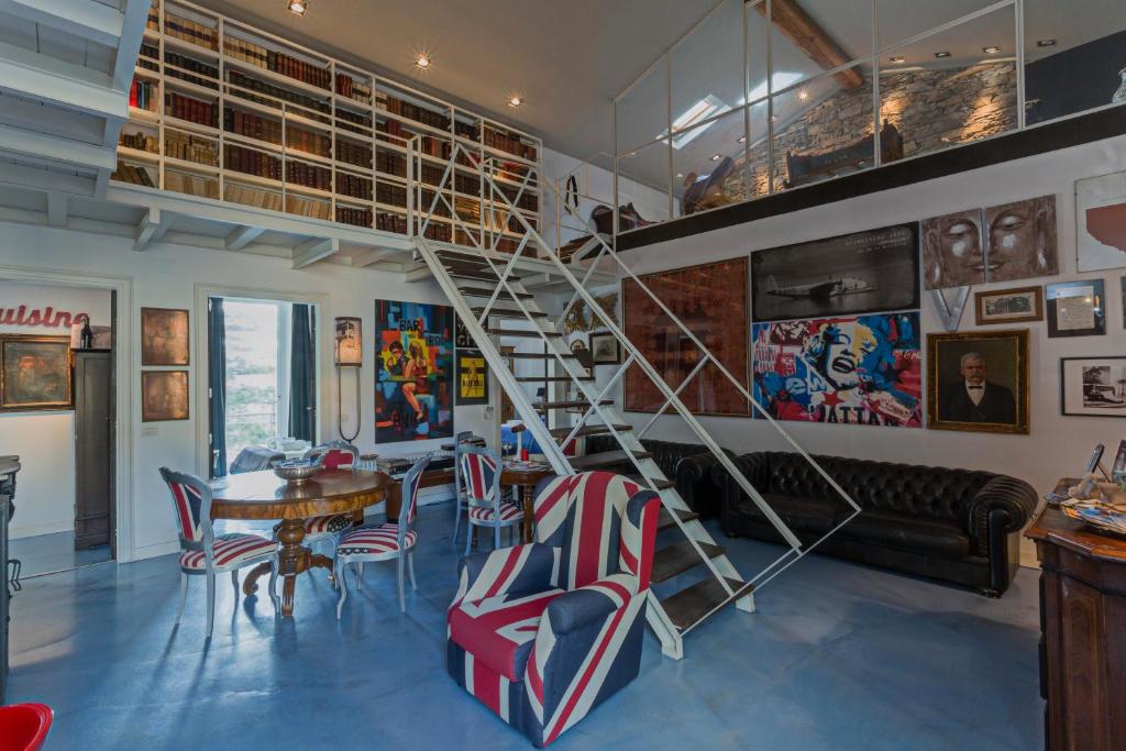 ein Wohnzimmer mit einer Wendeltreppe sowie einem Tisch und Stühlen in der Unterkunft Loft Garibaldi in Chiavari