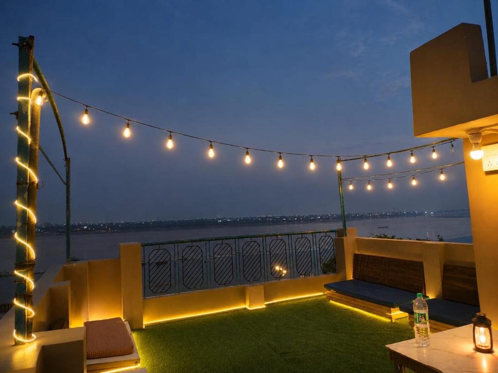 a patio with lights and a table on a balcony at MONALISA HOSTEL in Varanasi