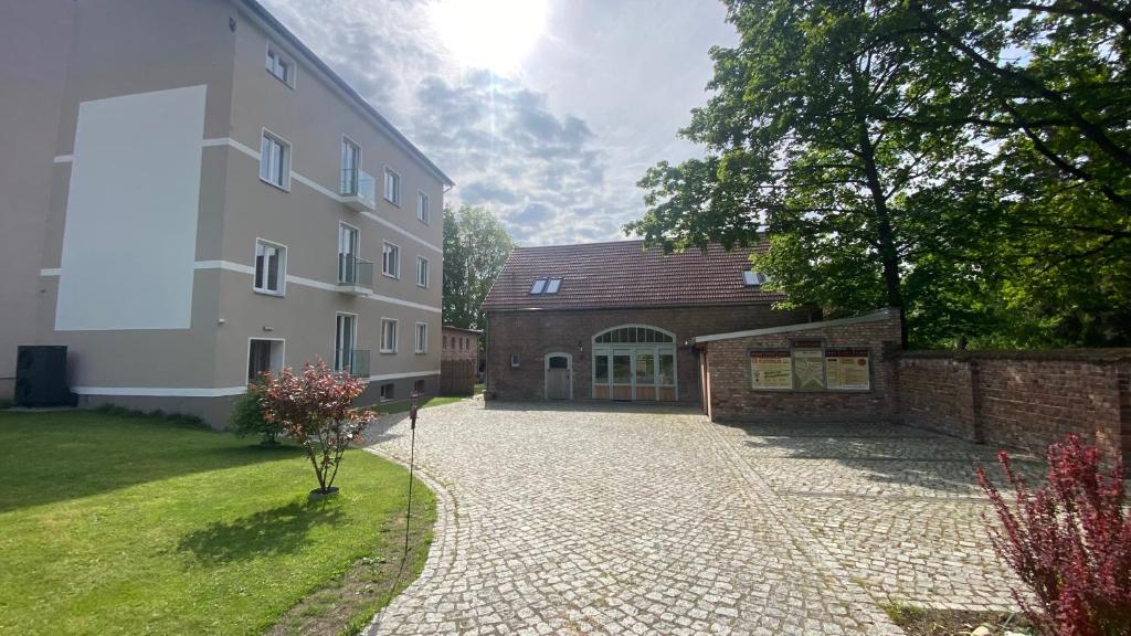 a building with a stone driveway next to a building at Ferienwohnung Carla Rohls in Königs Wusterhausen