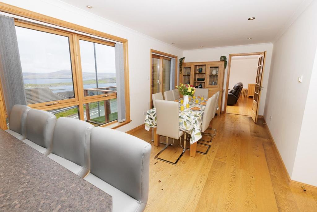 a dining room with a table and chairs and a window at Quoys Self Catering, Shetland in Lerwick