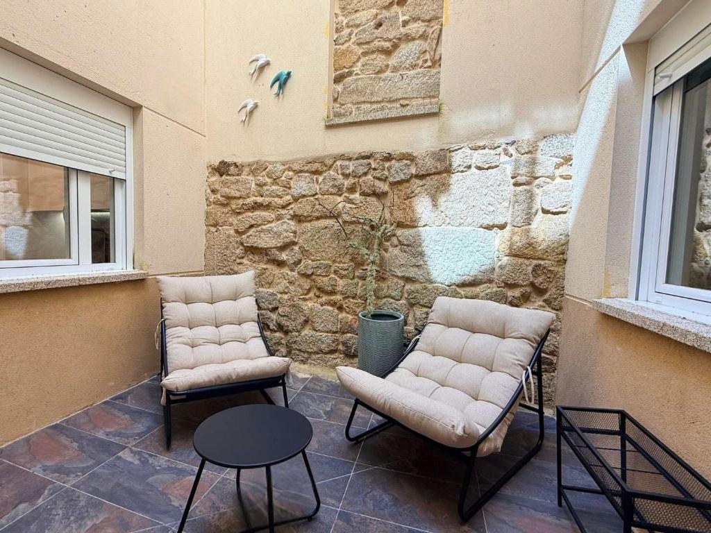two chairs and a table on a patio at YourHouse O Rexo in Allariz