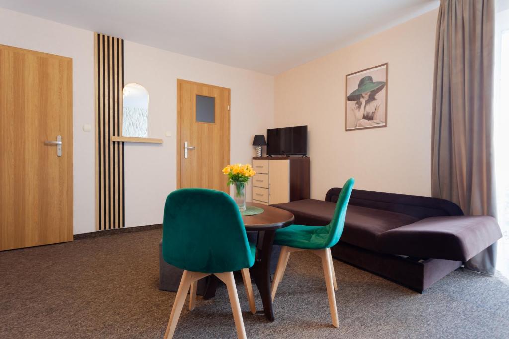 a living room with a couch and a table and chairs at Waldi in Grzybowo