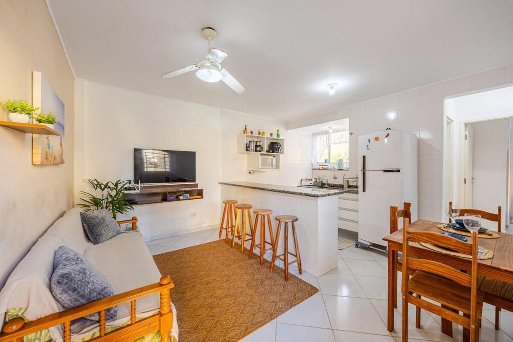 a living room and kitchen with a couch and a table at Casa a 500m da Praia do Sape in Ubatuba