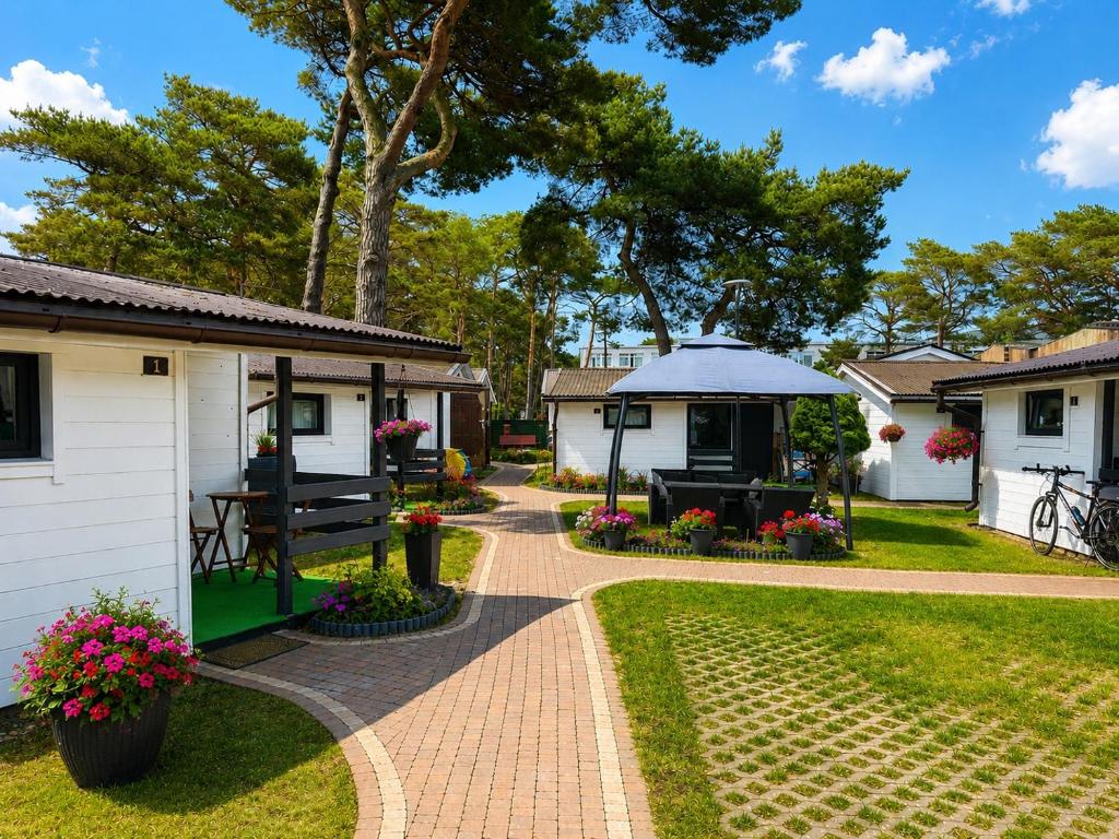 a garden with a table and a gazebo at Domki Promyk in Mrzeżyno