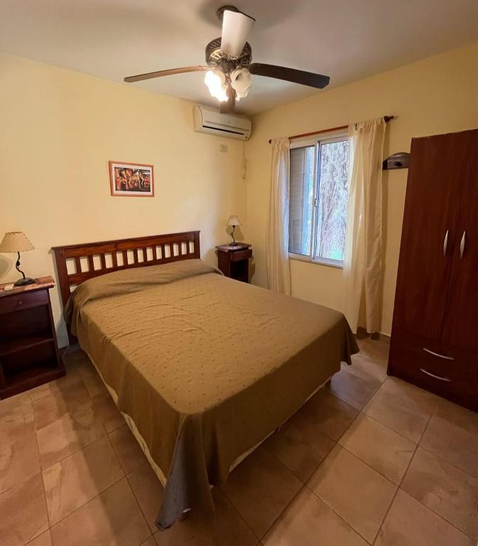 a bedroom with a bed and a ceiling fan at Amanecer y Canela in Mina Clavero