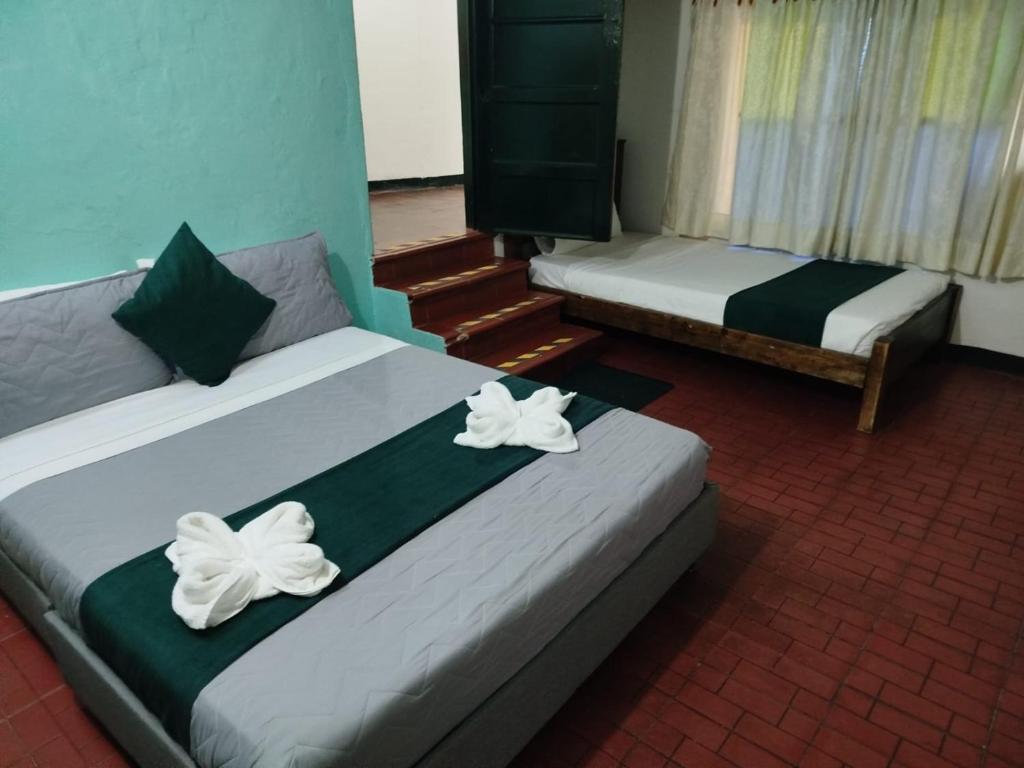 two beds with white flowers on them in a room at Tour La Matrona in Villa de Leyva