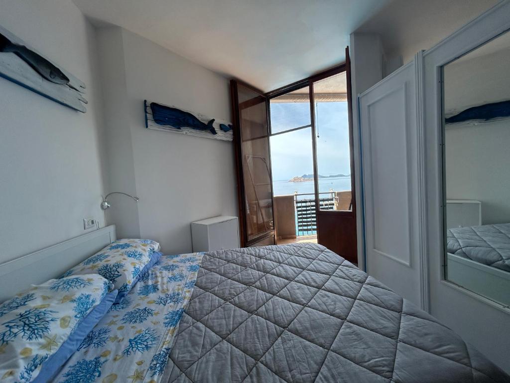 a bedroom with a bed and a large window at orizzonte mare in Teulada