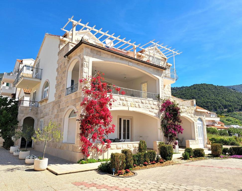 a large building with flowers in front of it at Studio Apartments Regina in Bol