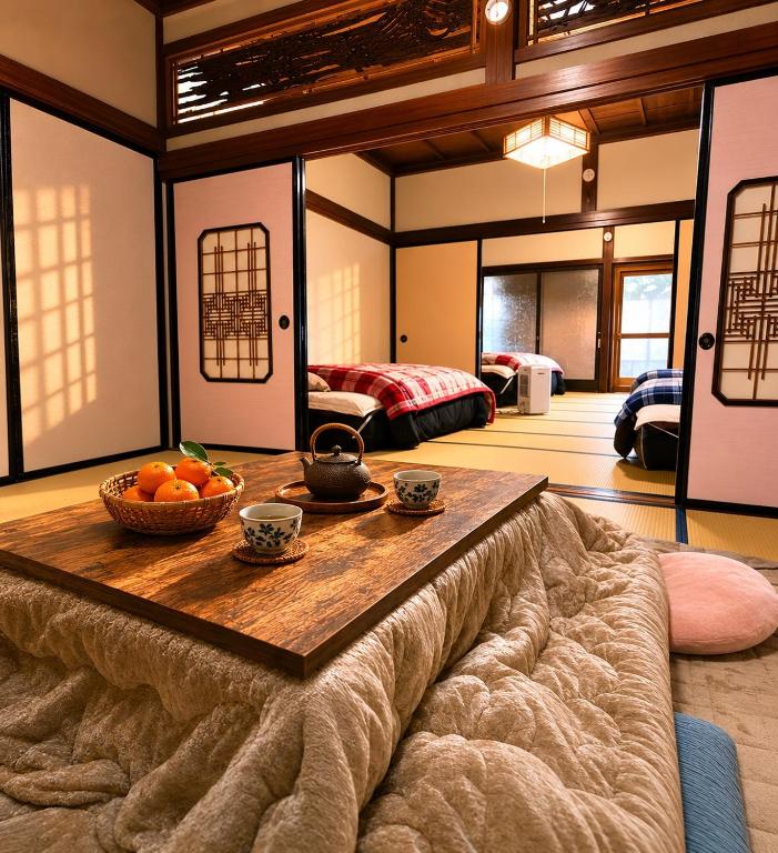 a room with a table with a bowl of fruit on it at Guesthouse今井邸 in Tonami
