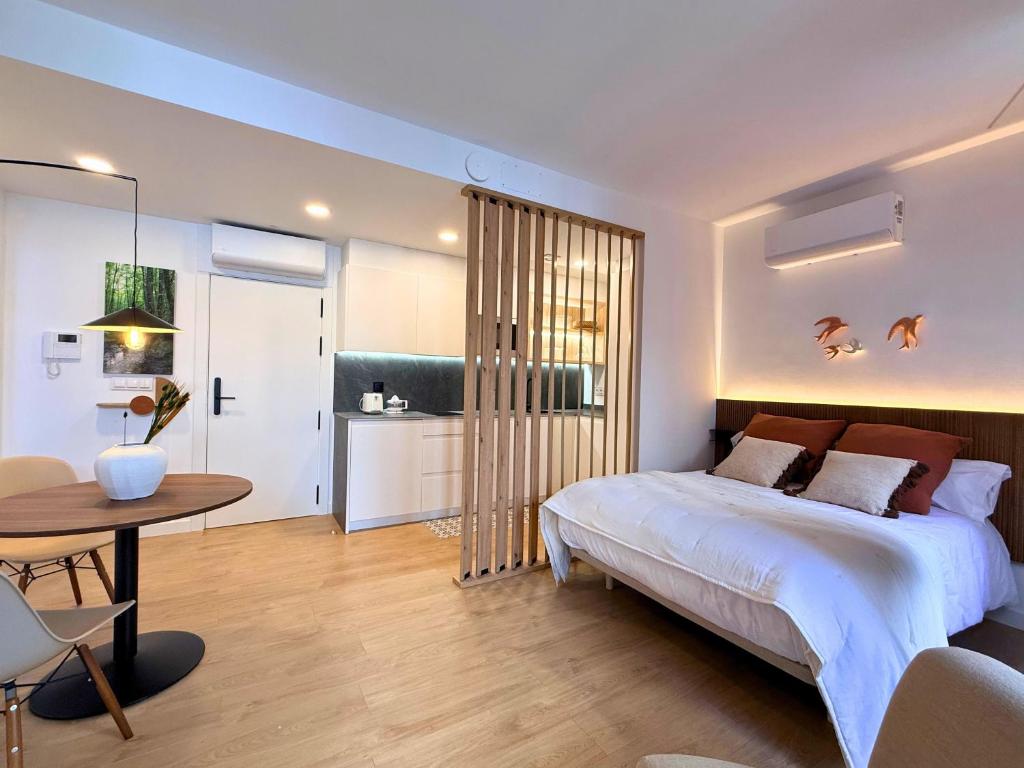a bedroom with a bed and a table and a kitchen at YourHouse O Foxo in Allariz