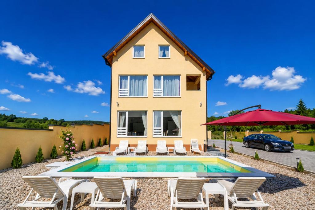 a villa with a swimming pool in front of a house at Planinska Oaza in Pale
