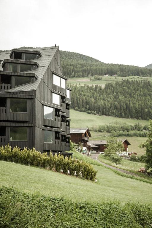 a building on a hill next to a green field at Bühelwirt in San Giacomo
