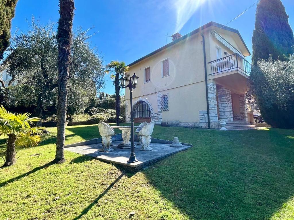 a house with a statue in front of a yard at Eden apartments 2 in Bardolino