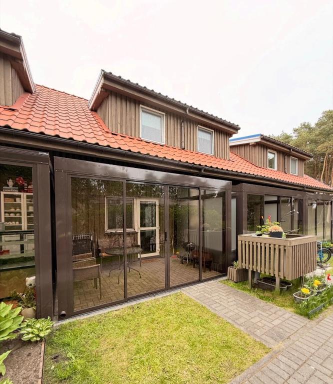 an extension of a house with sliding glass doors at Namelis Preiloje in Neringa