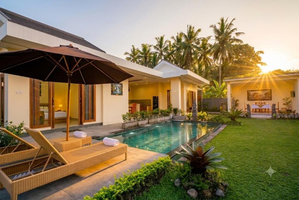 a house with a swimming pool and an umbrella at Sinden Villa in Payangan