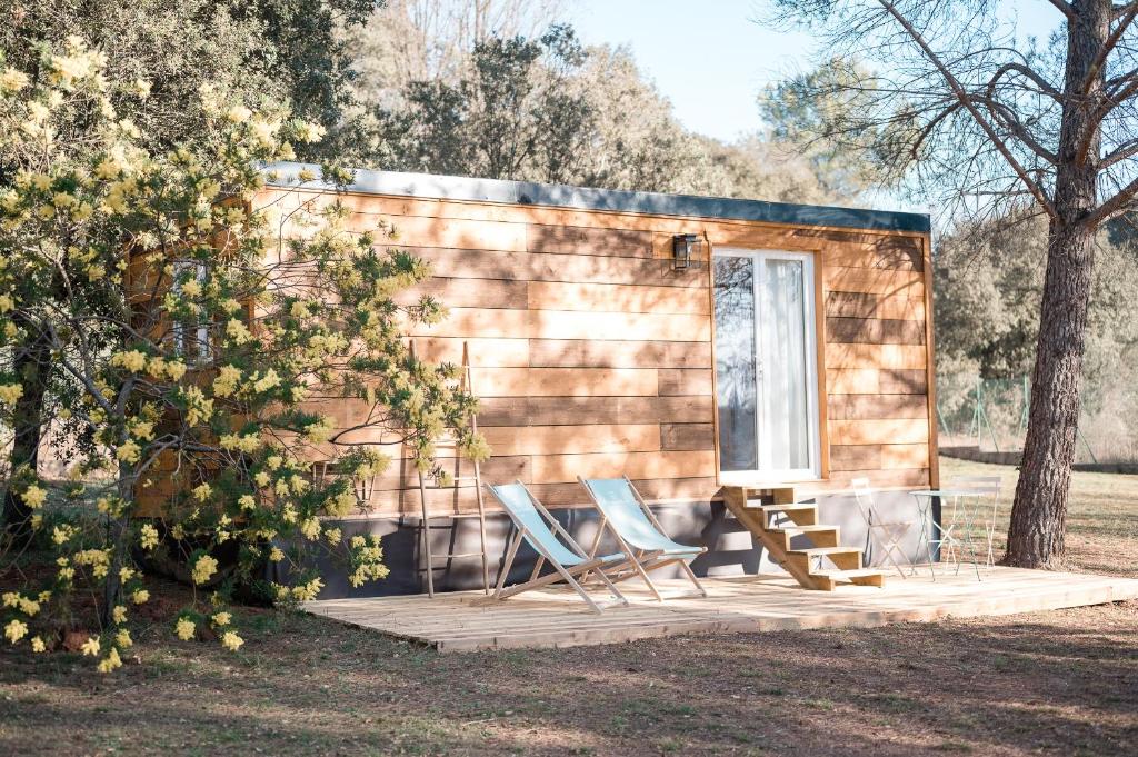 a tiny house with two chairs and a bench at La Petite Maison d'Emma in Vidauban