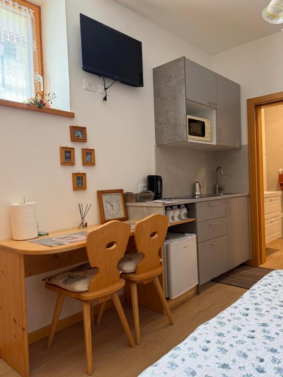 a kitchen with a desk and two chairs in a room at Residenza Dei Castelli in Coredo