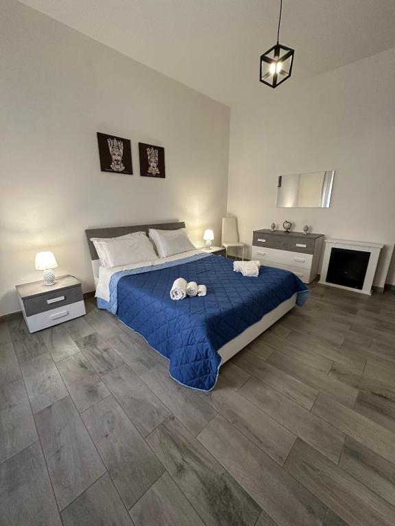 a bedroom with a blue bed with two pillows on it at Casa Inyco in Menfi