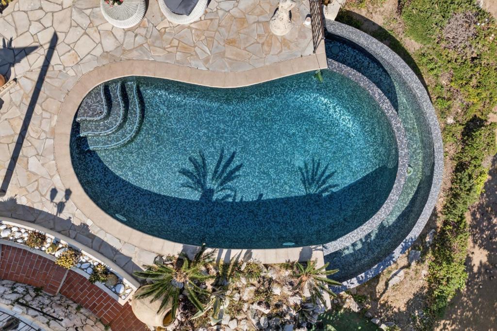 an overhead view of a swimming pool with palm trees at Villa Panorama in Éze