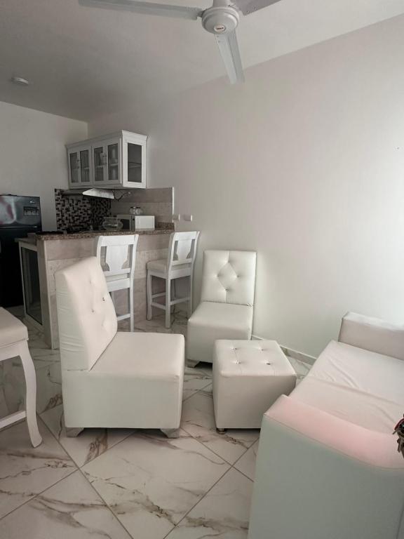 a living room with white furniture and a kitchen at SahiR 2 in Cantabria