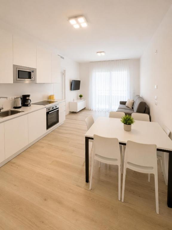 a kitchen and living room with a table and chairs at Haus Margarete - Agenzia Cocal in Caorle