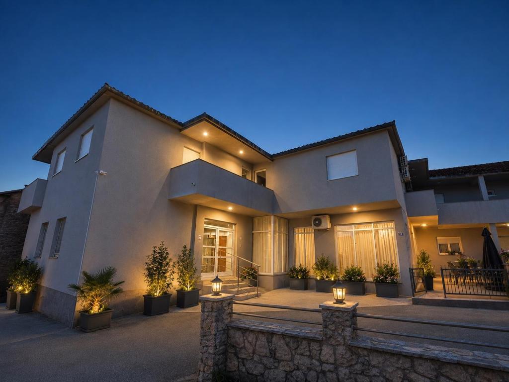 a large house with lights on the front of it at Sobe Ivan-Popić in Međugorje
