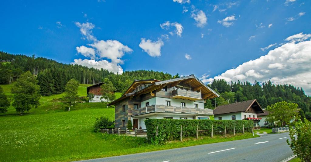 a house on a hill next to a road at Haus Gsenger in Eben im Pongau