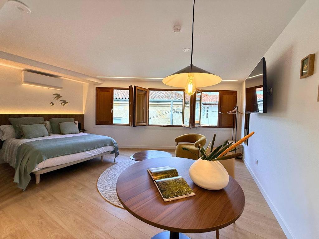 a bedroom with a bed and a table in a room at YourHouse As Escadas in Allariz
