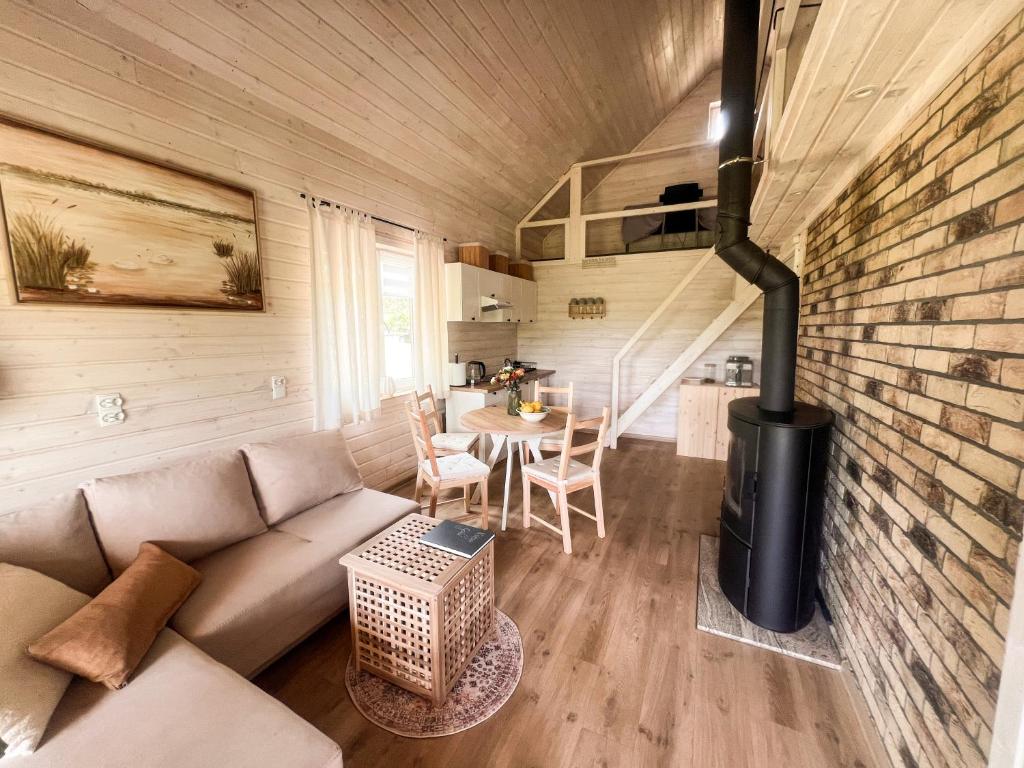 a living room with a couch and a stove at Serce Puszczy in Drawsko