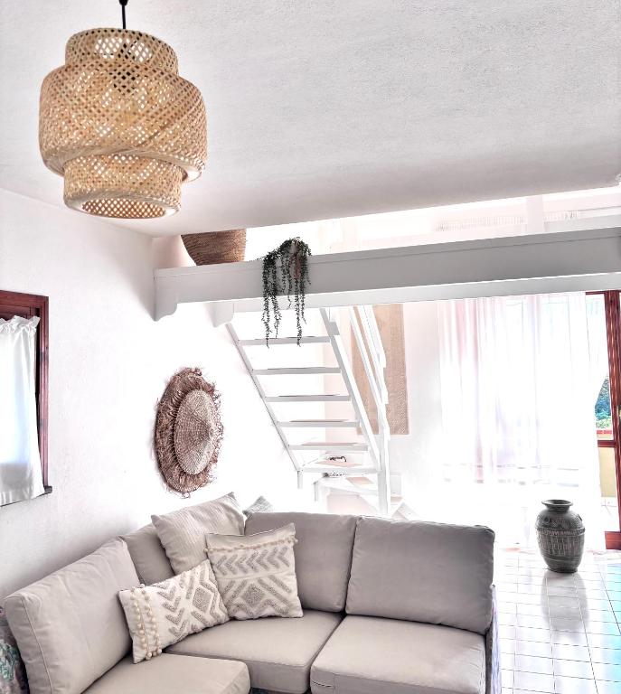a living room with a couch and a staircase at Grace House in Marina di Sorso