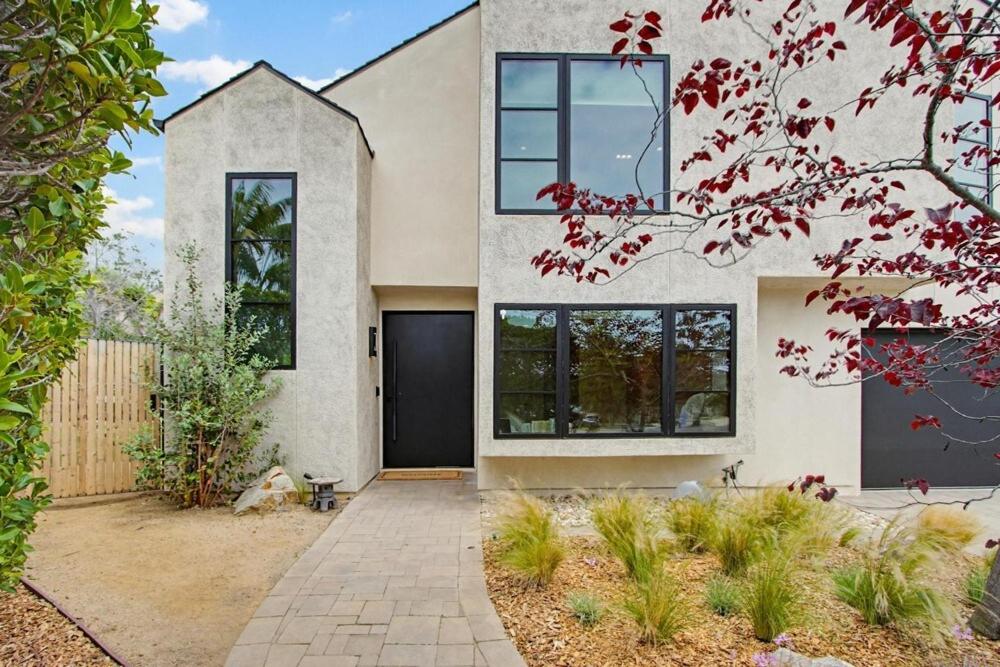 a large white house with a black door at Modern Encinitas Retreat in Encinitas