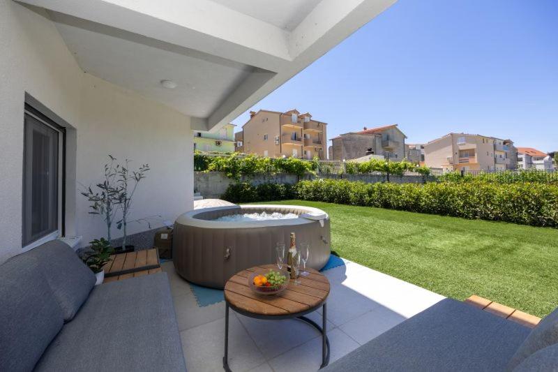 a patio with a jacuzzi tub in a yard at Lux suite in Split- Jacuzzi&Gym&more in Solin